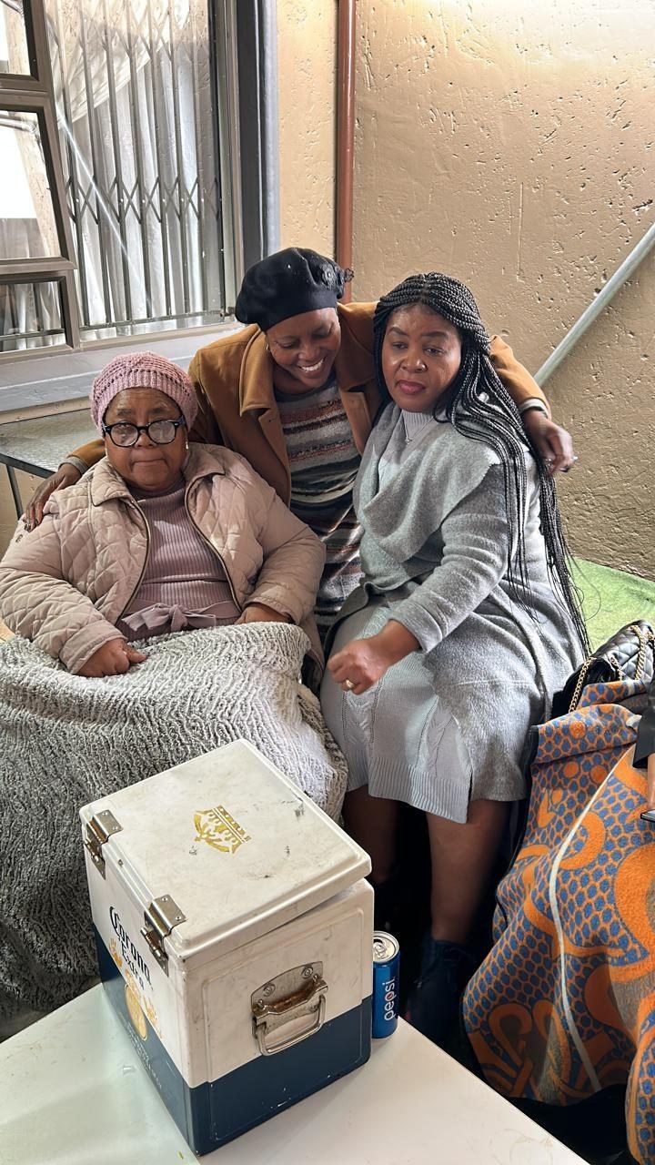 Lindiwe Millicent Mokuena seated with loved ones.